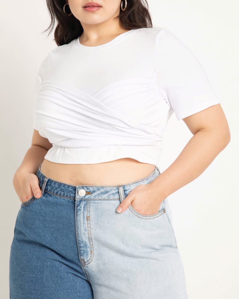 Front of a model wearing a size 14|16 Sylvia Wrap Front Tee in True White by ELOQUII. | dia_product_style_image_id:196080